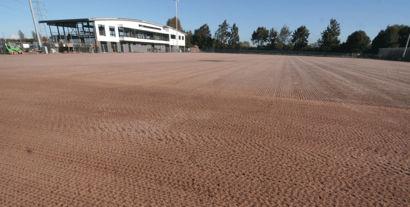 Prepared pitch profile with a training-facility building beyond