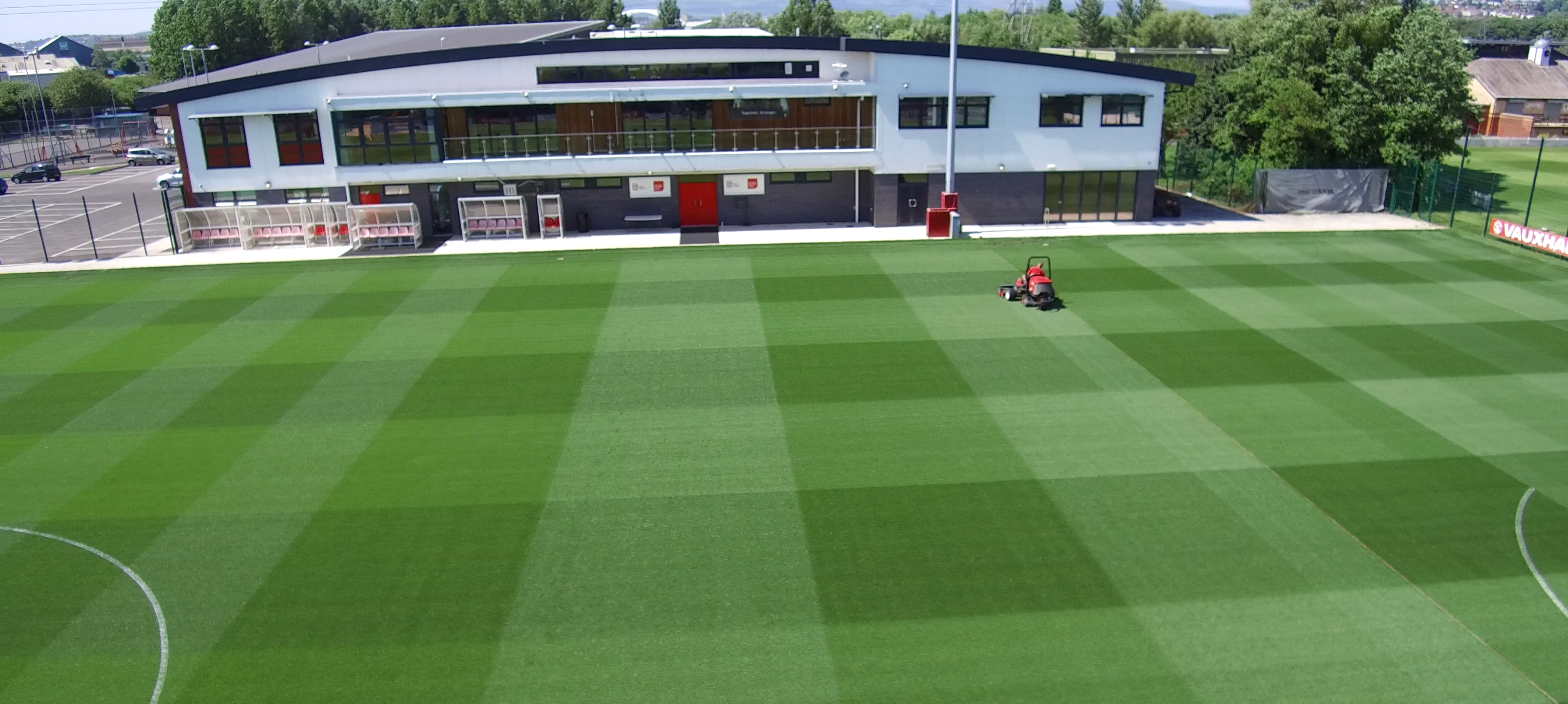 Striped football training pitch in front of the Dragon Park facility building