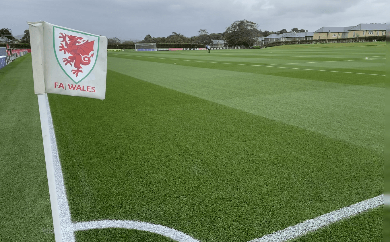 FAW corner flag beside a marked natural-turf training pitch