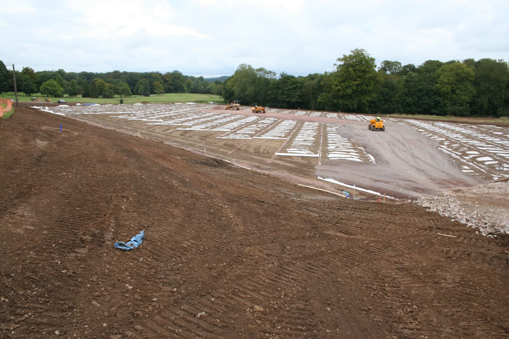 Prepared ground with white material exposed along drainage lines