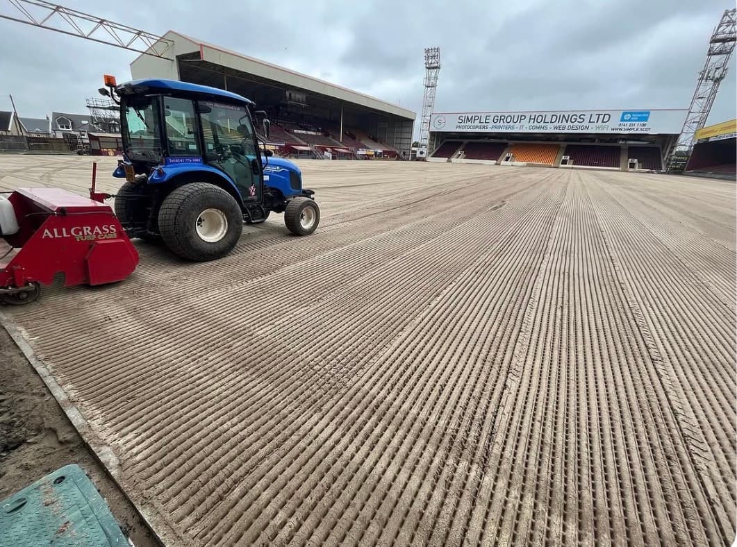 Tractor working across the ridged pitch surface at Fir Park
