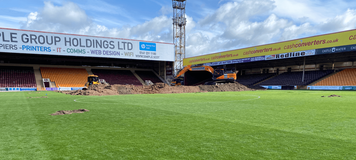 Excavators removing the existing pitch surface inside Fir Park Stadium