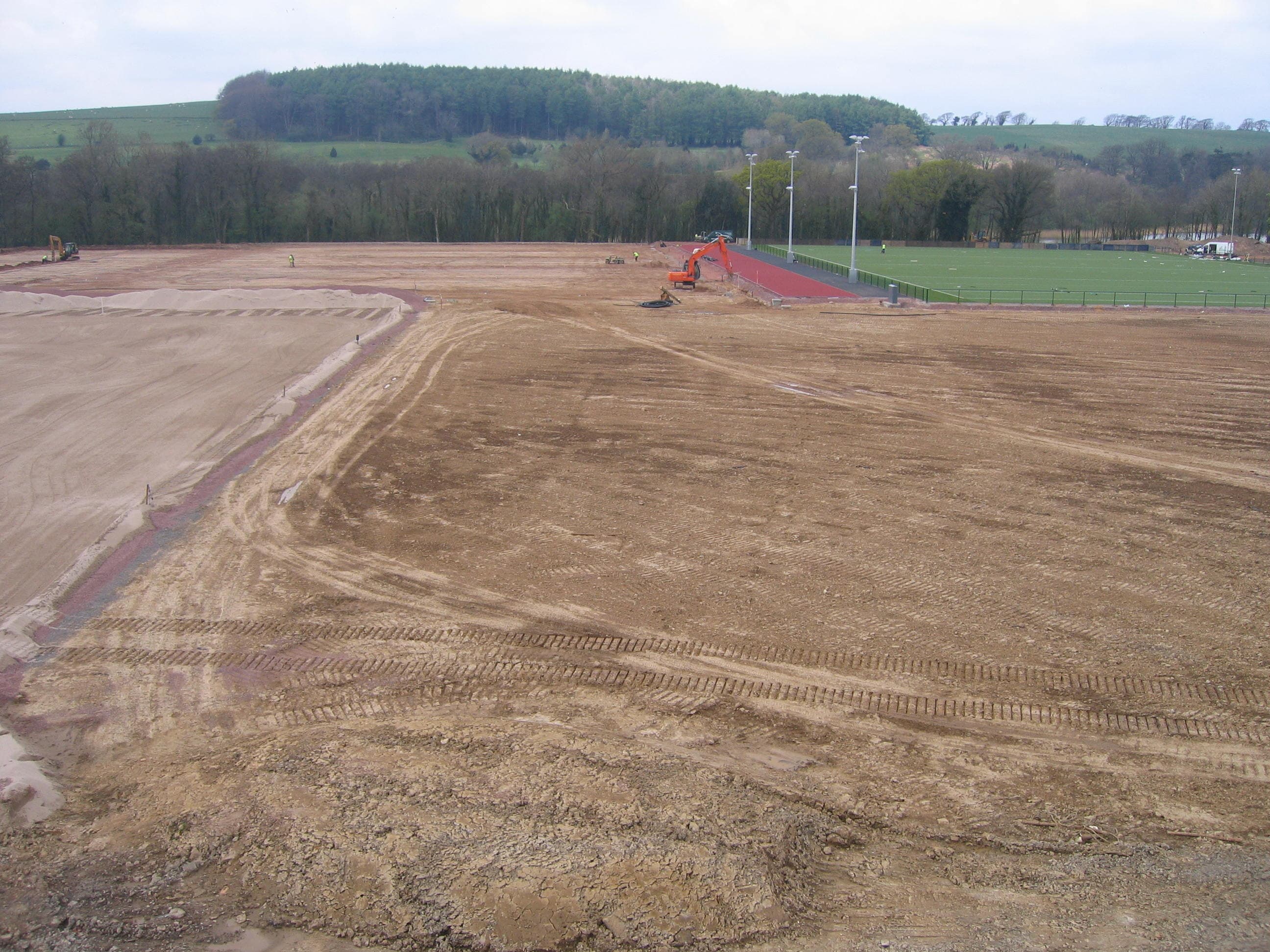 Training-facility earthworks beside a synthetic pitch and sprint track