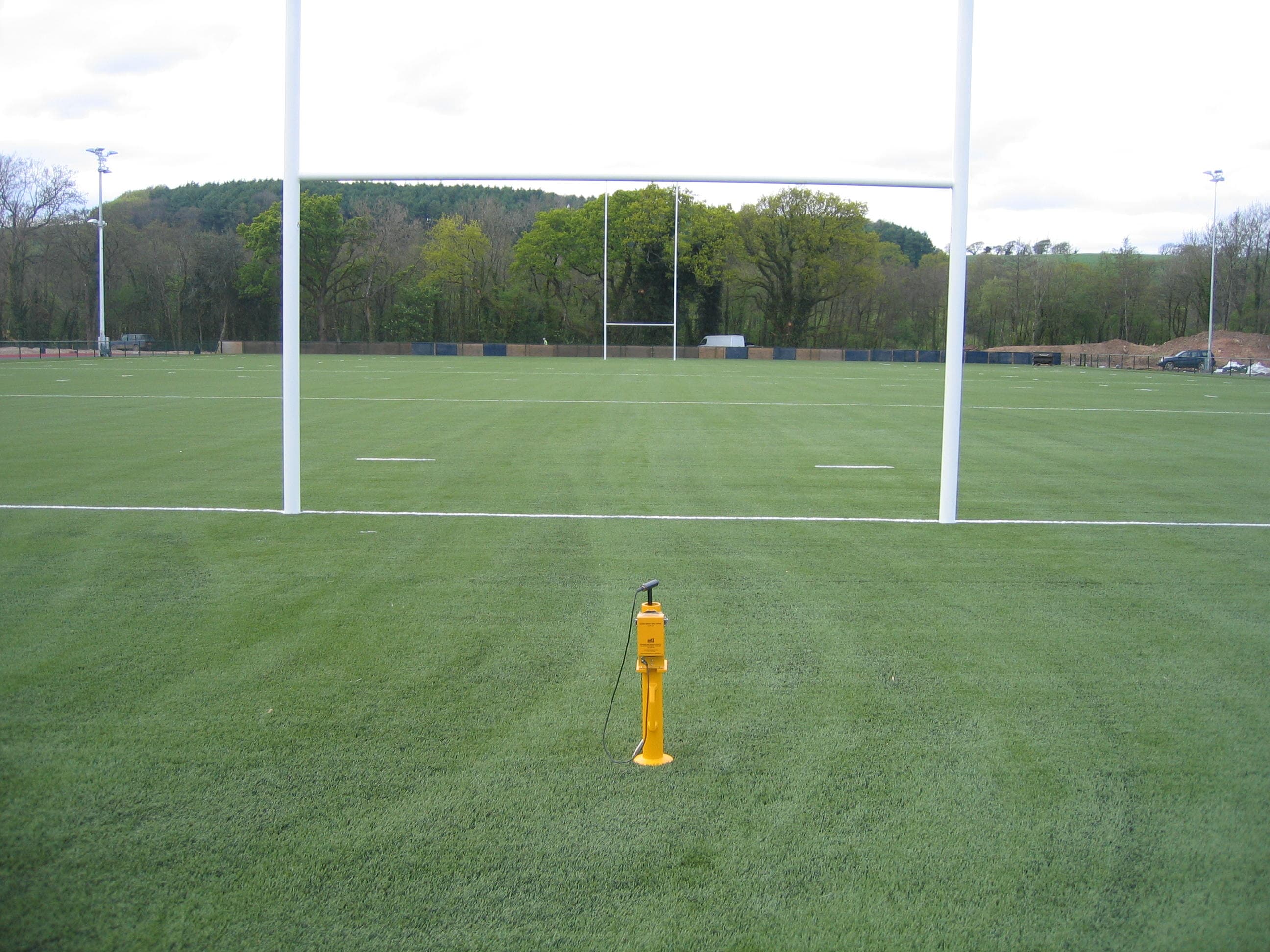 Synthetic rugby pitch with goalposts and floodlight columns