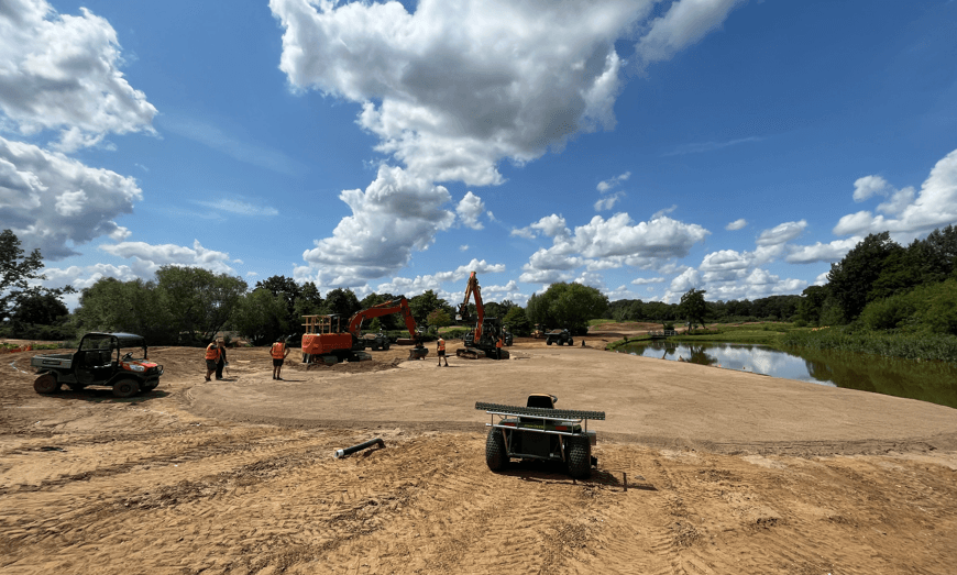 Construction plant and prepared ground beside water on the golf course
